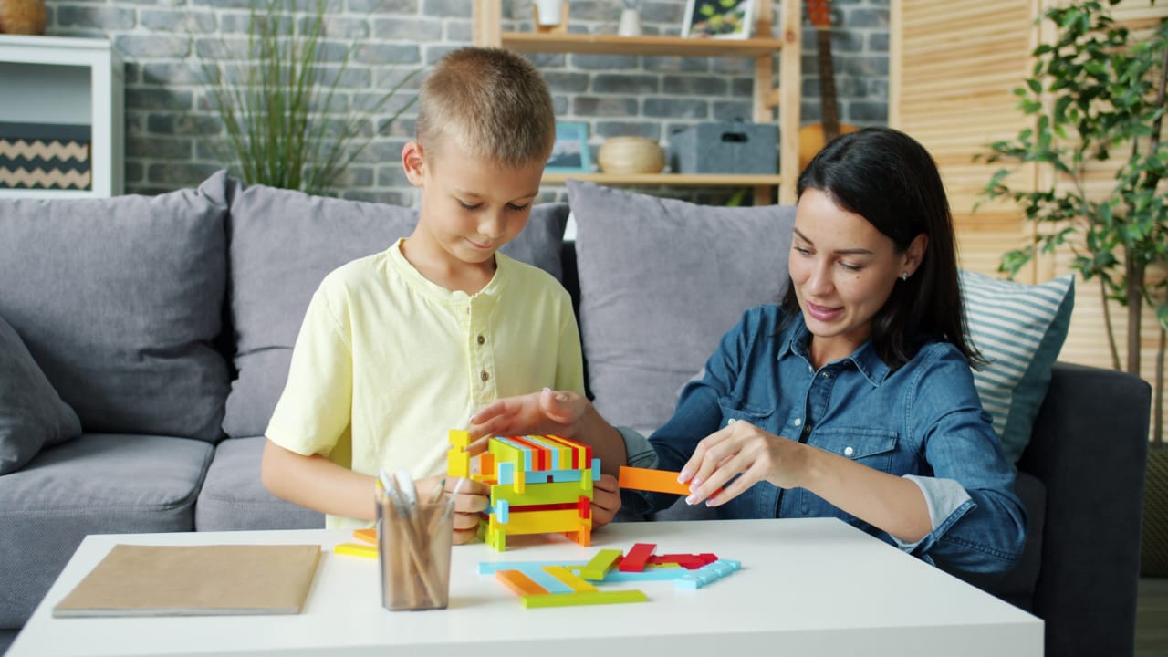 A child and an adult assembling a colourful construction together